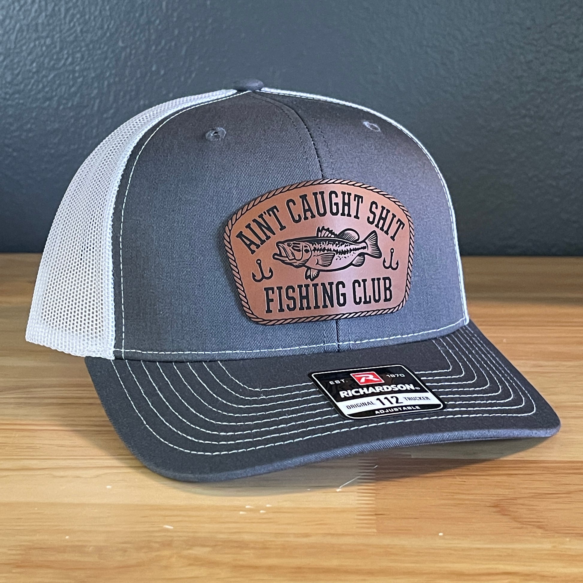 Ain't Caught Shit Fishing Club Leather Patch Trucker Hat. Richardson 112.