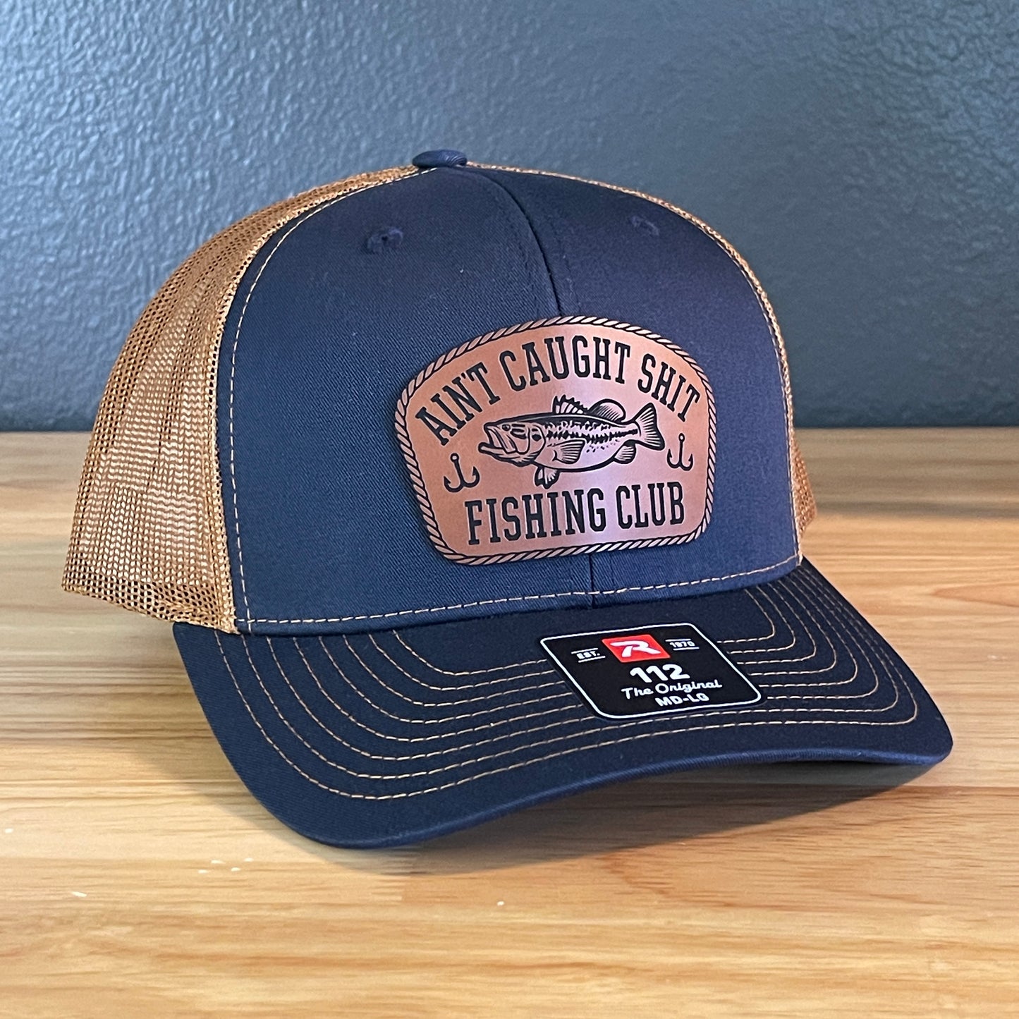 Ain't Caught Shit Fishing Club Leather Patch Trucker Hat. Richardson 112.