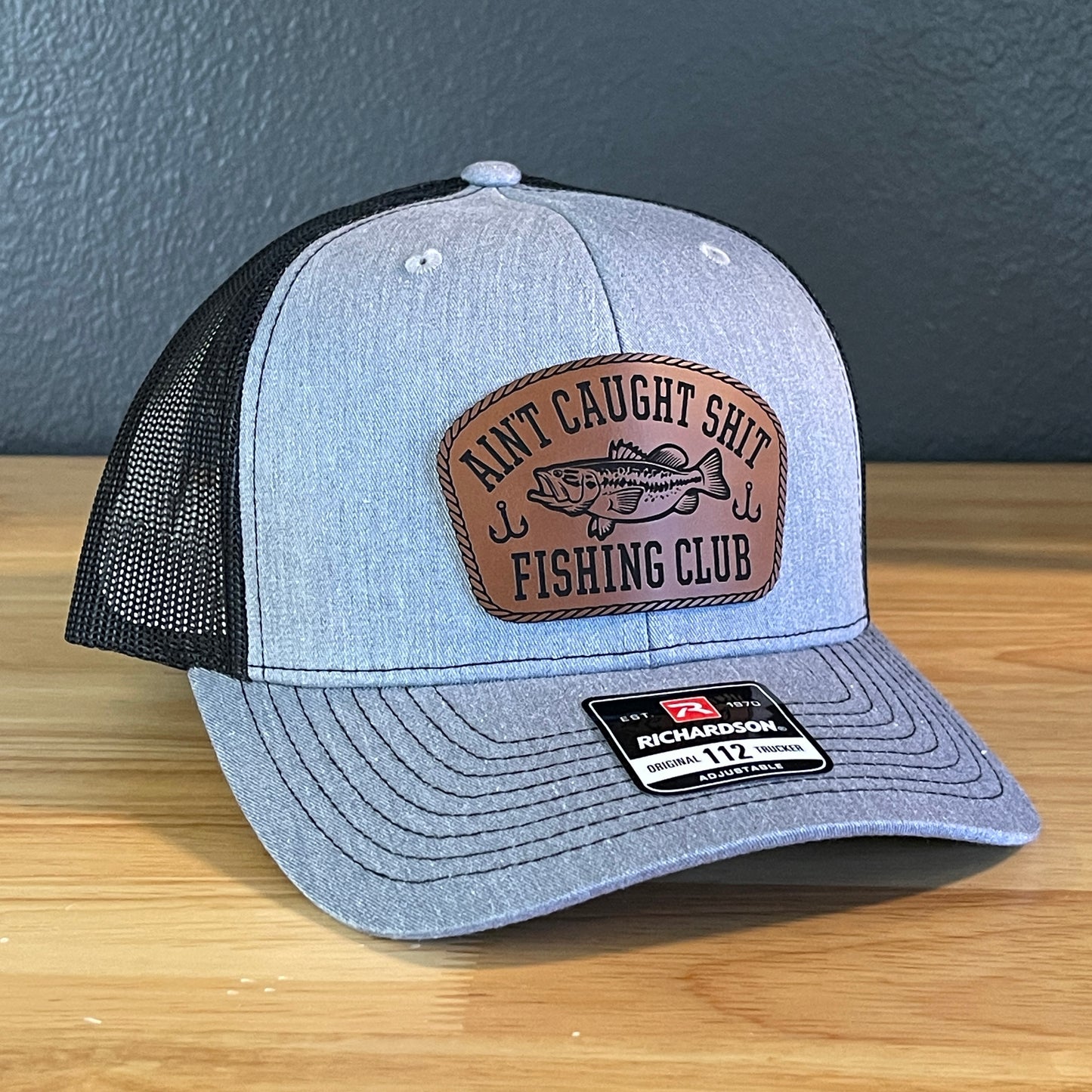 Ain't Caught Shit Fishing Club Leather Patch Trucker Hat. Richardson 112.