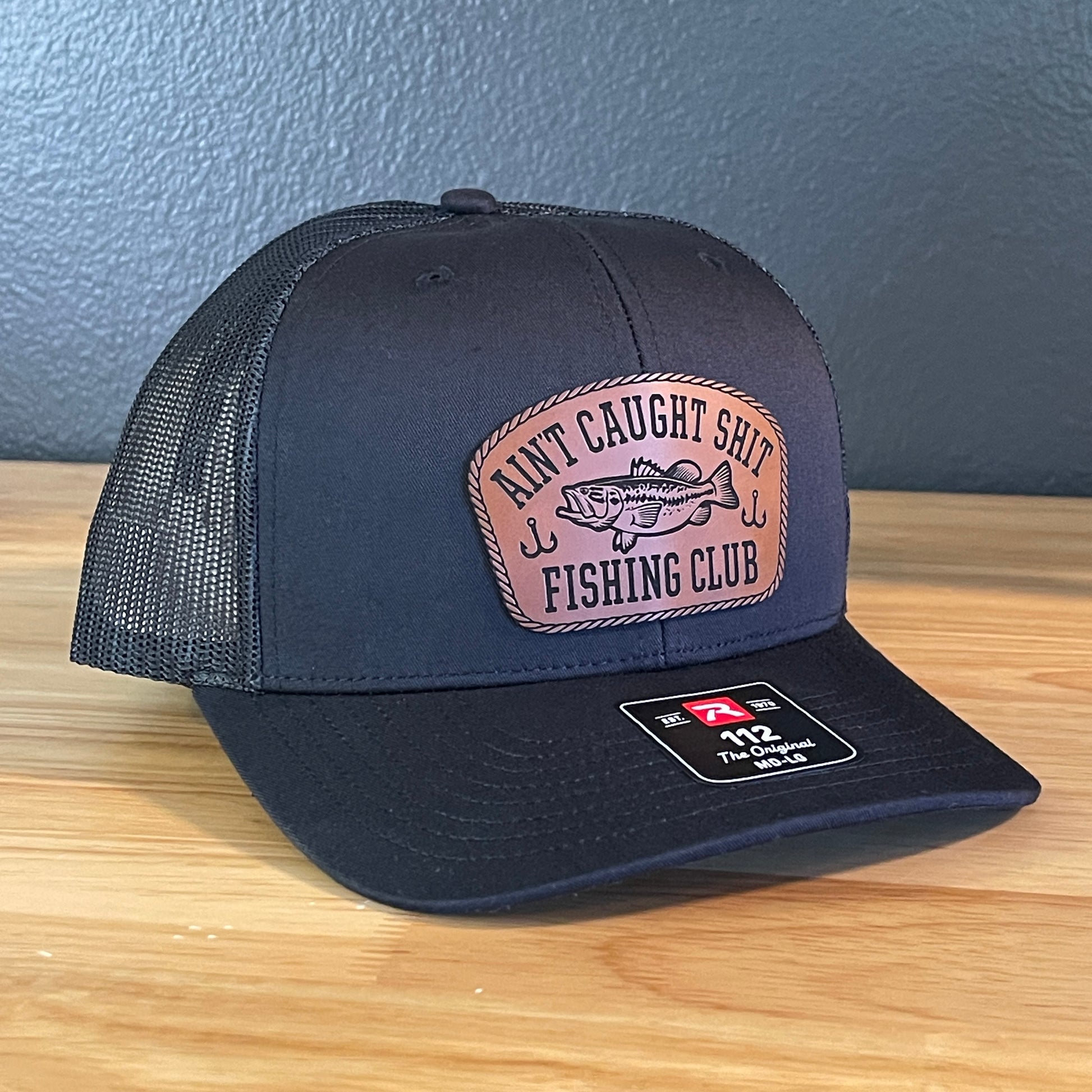 Ain't Caught Shit Fishing Club Leather Patch Trucker Hat. Richardson 112.