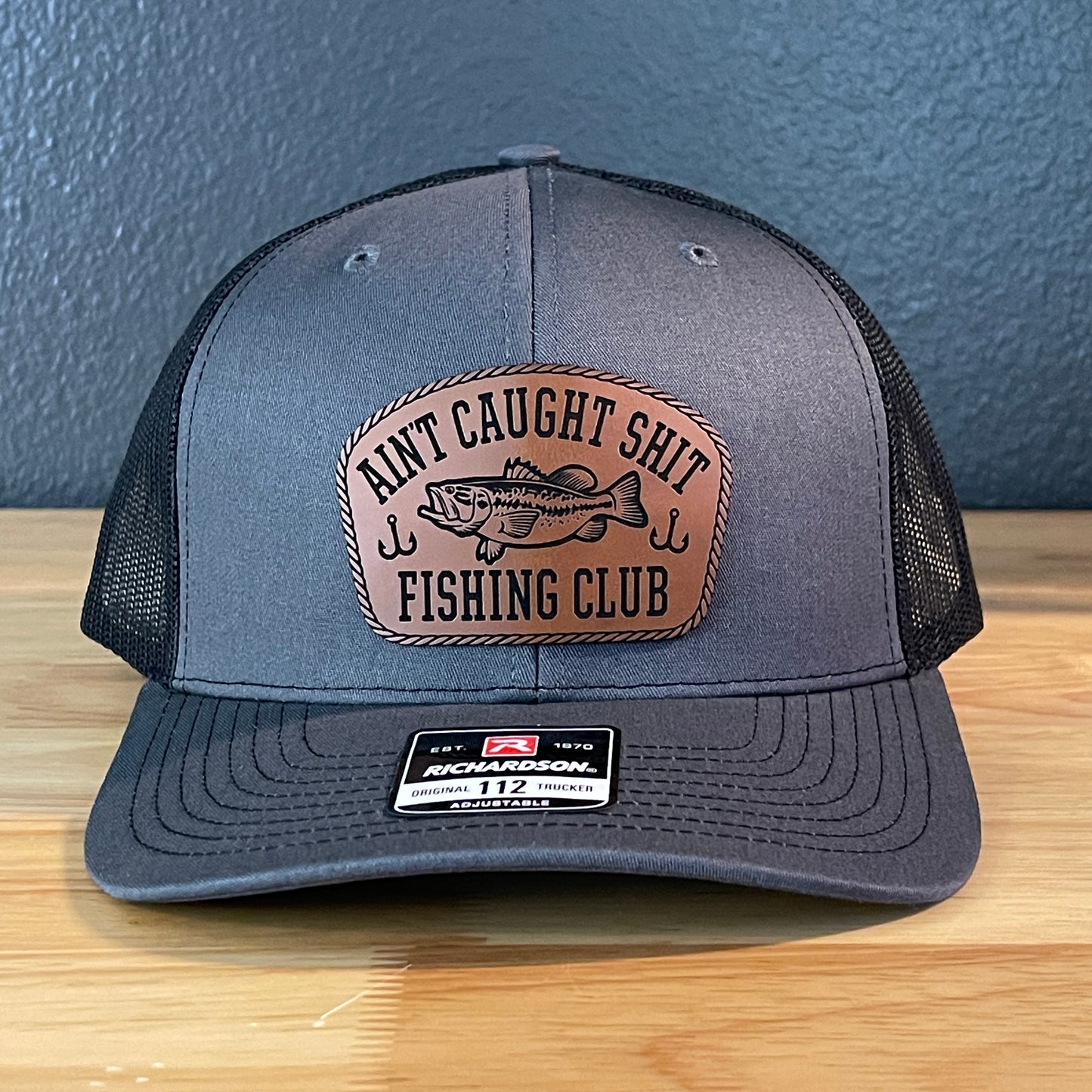 Ain't Caught Shit Fishing Club Leather Patch Trucker Hat. Richardson 112.