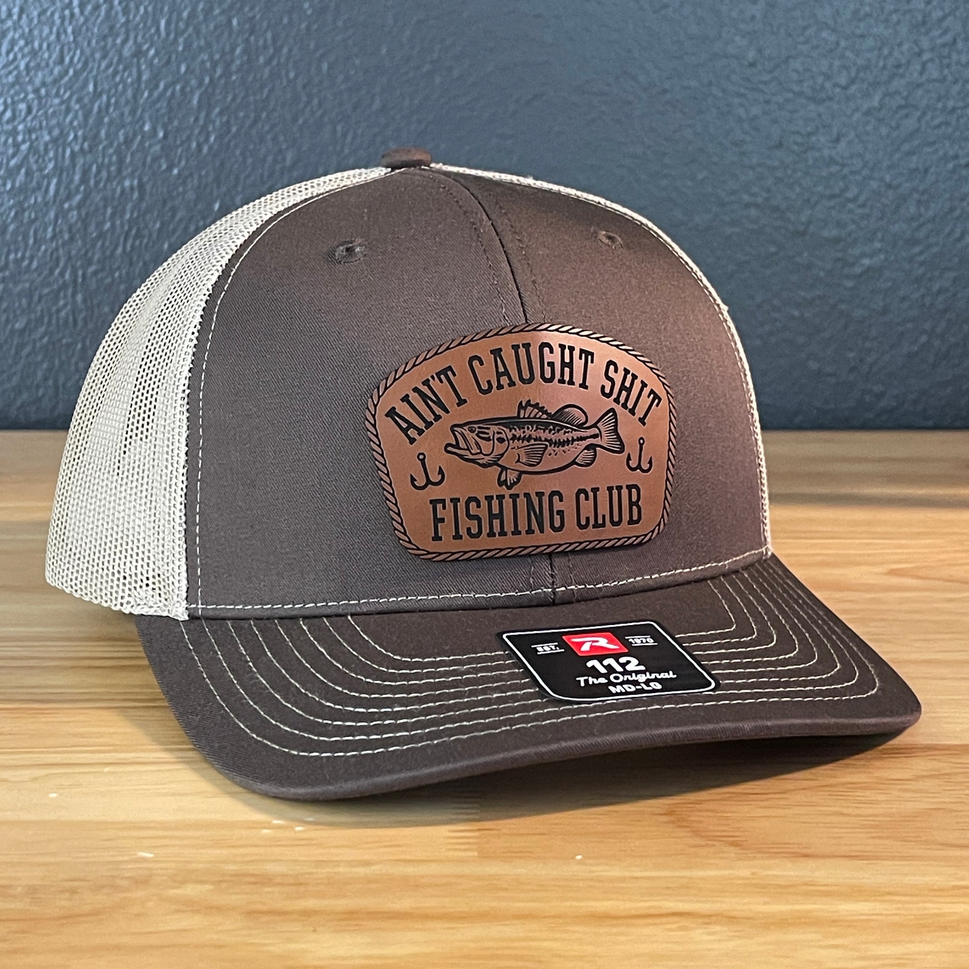 Ain't Caught Shit Fishing Club Leather Patch Trucker Hat. Richardson 112.